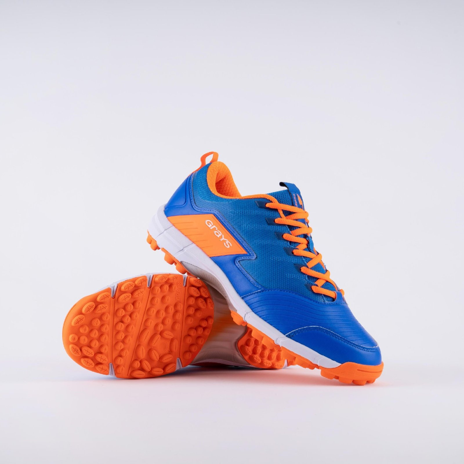 Grays Flash 3.0 Hockey Shoes - Blue/Orange (2022/23) - Grays Flash 3.0 hockey shoes in blue and orange, side view with the second shoe tilted to show the orange studded sole.